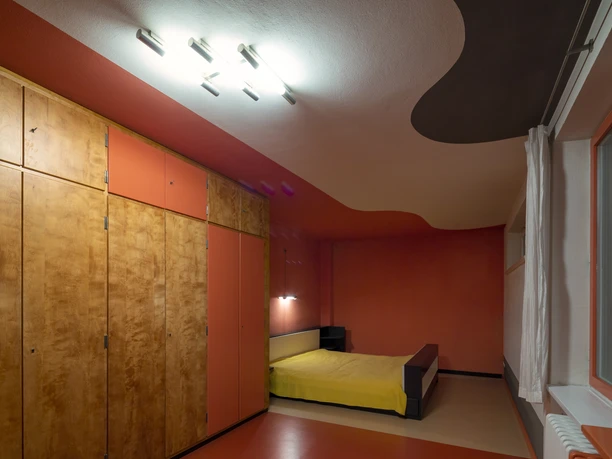 Dans la chambre à coucher de la Haus Rabe Zwenkau se trouvent une grande armoire murale et un lit.