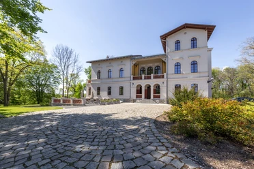 Herrenhaus Möckern - Gastronomie in Leipzig Blick auf das Herrenhaus Möckern, bei Sonnenschein mit Vorgarten und umgeben von Grün, Veranstaltung, restaurant, gastronomie