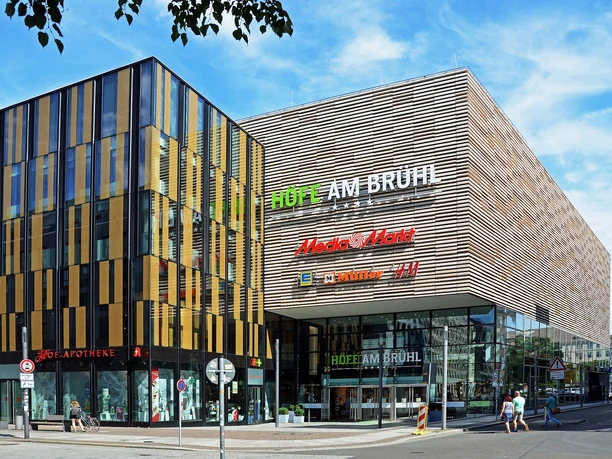 Pohled na vchod do nákupního centra Höfe am Brühl, kde se nachází řada obchodů pro nákupy a volný čas.