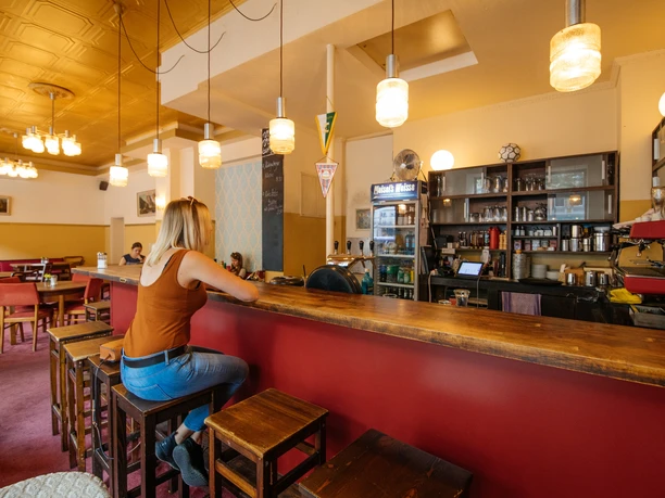 Blick in den Innenraum des Hotel Seeblicks, eine junge Frau sitzt am Tresen der Bar, Restaurant, gastronomie, kulinarik