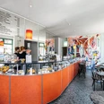 INO Café - Cafés in Leipzig Blick auf den Bar-Bereich des INO Cafés mit seiner Theke, der Bestuhlung und den Utensilien hinter der Bar, cafe, kaffeehaus, genuss, gastronomie