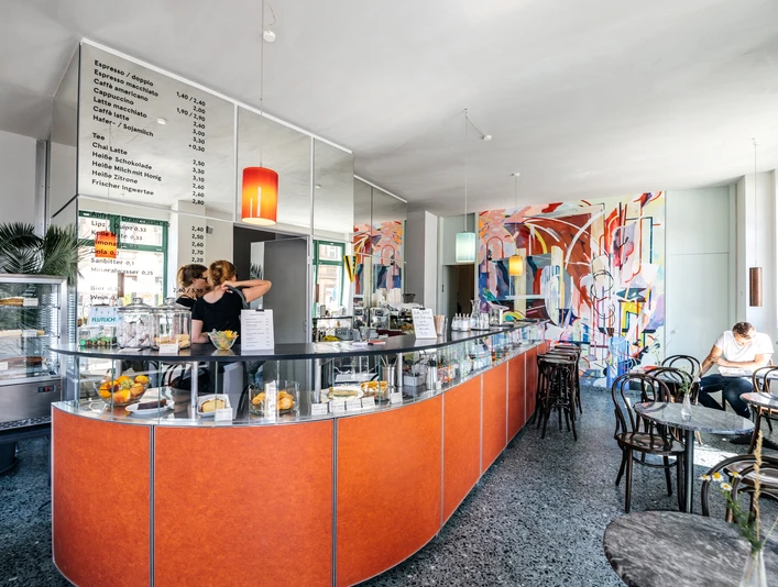 INO Café - Cafés in Leipzig Blick auf den Bar-Bereich des INO Cafés mit seiner Theke, der Bestuhlung und den Utensilien hinter der Bar, cafe, kaffeehaus, genuss, gastronomie