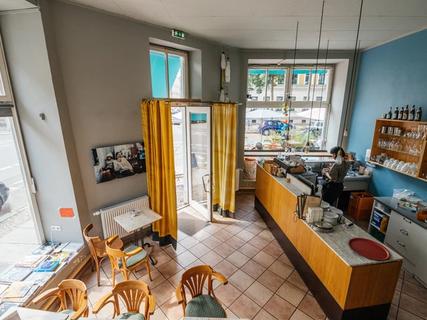 Jimmy Orpheus - Cafés in Leipzig Blick inn das farbenfrohe Jimmy Orpheus-Café aus der Vogelperspektive; mit Blick auf Sitzbereich, Theke, Fensterfronten
