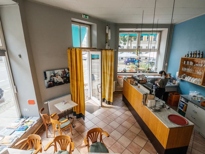 Jimmy Orpheus - Cafés in Leipzig Blick inn das farbenfrohe Jimmy Orpheus-Café aus der Vogelperspektive; mit Blick auf Sitzbereich, Theke, Fensterfronten