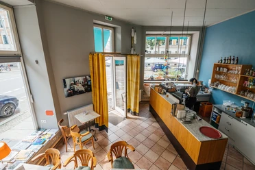 Vue aérienne du café coloré Jimmy Orpheus, avec vue sur les sièges, le comptoir et les fenêtres.