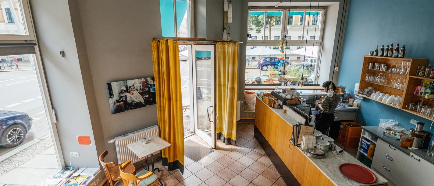 Jimmy Orpheus - Cafés à Leipzig Vue aérienne du café coloré Jimmy Orpheus, avec vue sur les sièges, le comptoir et les fenêtres.