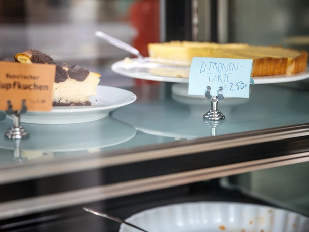 Jimmy Orpheus - Cafés in Leipzig Aufnahme der köstlichen Kuchen, die sich mitsamt Beschilderung in der Glas-Vitrine des Jimmy Orpheus-Café befinden, restaurant, cafe, kulinarik, genuss, freizeit