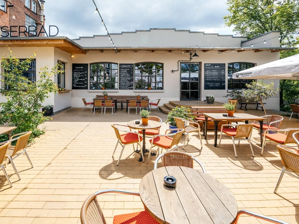 Kaiserbad - Gastronomie in Leipzig Fotografie des Außenbereiches des Kaiserbads im Leipziger Westen bei Sonnenschein; Sitzbereich, eingedeckte Cafétische, Gastronomie, freisitz