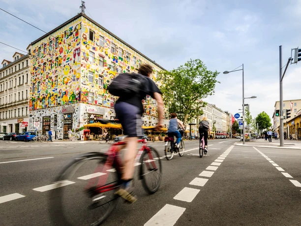 Karl-Liebknecht-Straße - Szenemeilen in Leipzig Ein Fahrradfahrer fährt auf der Szenemeile Karl-Liebknecht-Straße, die auch Karli genannt wird und auf der sich viele Bars und Restaurants mit Freisitz befinden