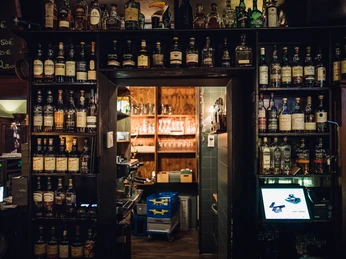 Killiwilly - Gastronomie in Leipzig Blick auf die Wand mit unterschiedlichsten Flaschen im Killiwilly, direkt neben der Kasse und mit Blick in einen der hinteren Räume, gastronomie, kneipe, bar