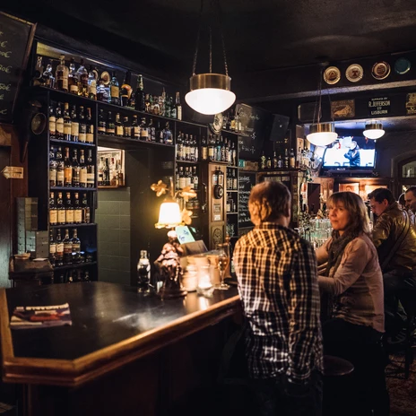 Akcja w pubie, goście siedzą przy barze i rozmawiają w przytulnej atmosferze, pub, gastronomia