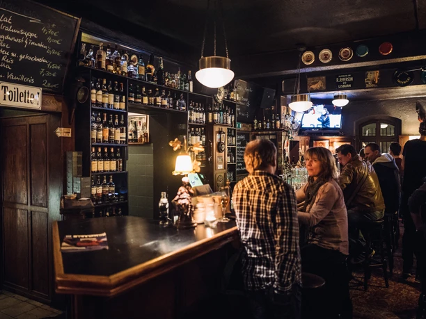 L'activité du pub, les clients sont assis au bar et discutent dans une ambiance chaleureuse, pub, pub, gastronomie