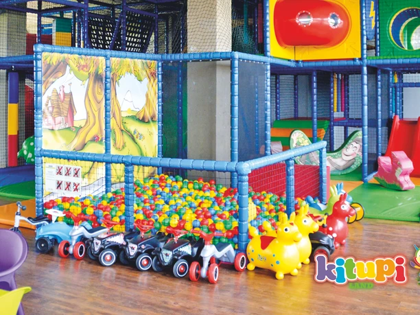 On peut y voir une construction d'escalade colorée pour les enfants avec une piscine de balles, des bobbycars et d'autres jouets colorés, des vacances en aire de jeux intérieure de loisirs