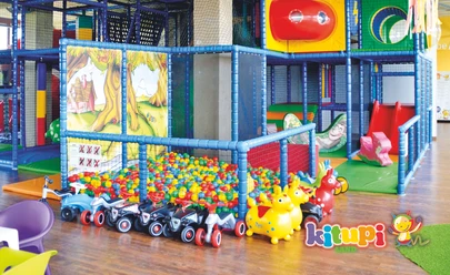 Spieleparadies-Kinder-Kitupi-Land-Leipzig.travel.jpeg Zu sehen ist ein buntes Kletterkonstrukt für Kinder mit einem Bällepool, Bobbycars und weiteren bunten Spielzeugen, Freizeit-Indoorspieplatz-Ferien