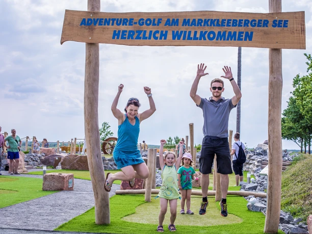 Familie auf der Adventure-Golfanlage am Markkleeberger See - Freizeit in Leipzig und Region Eine glückliche Familie macht Freudensprünge auf der Adventure-Golfanlage am Markkleeberger See, Freizeit, Familienausflug