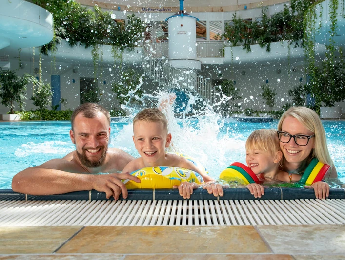 Riff-Bad-Lausick-Freizeit-Familie-Ausflug-Kur-und-Freizeitbad-RIFF-Bad-Lausick-Leipzig-Travel.jpeg Eine Familie mit 2 Kindern plantscht am Beckenrand des RIFF's, Schwimmbad-Leipzig-mit-Kindern-Freizeit