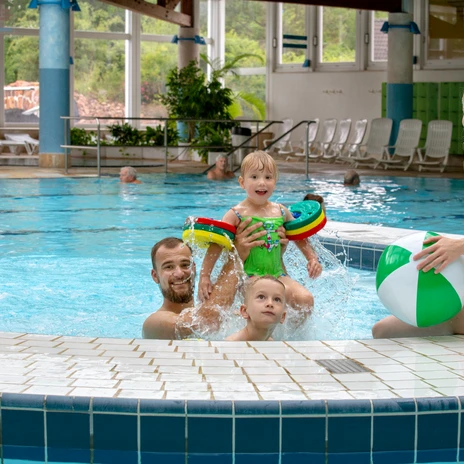 Eine glückliche Familie mit einem Wasserball im Schwimmbecken des Freizeitbades Riff in Bad Lausick