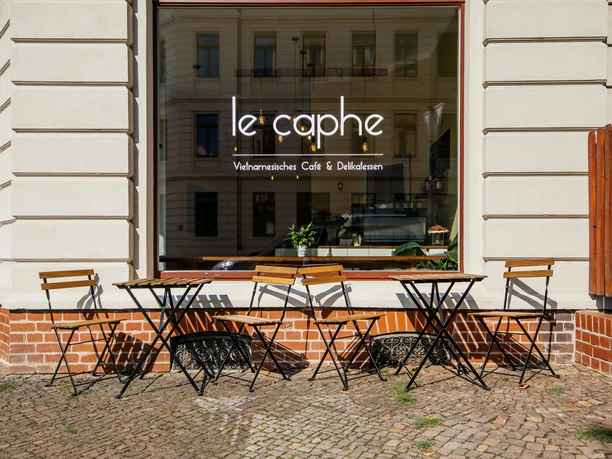 Le caphe - Cafés in Leipzig Blick auf den Freisitz (Stühle und Tische) vor dem le caphe sowie die Aufschrift der Ladenbezeichnung auf dem großen Fenster, gastronomie, cafe, freizeit