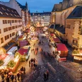 Weihnachtsmarkt auf dem Nikolaikirchhof - Weihnachten in Leipzig Blick von oben auf den Weihnachtsmarkt auf dem Nikolaikirchhof mit der Alten Nikolaischule auf der linken und der Nikolaikirche auf der rechten Seite, dazwischen Weihnachtsmarktbuden und einige Besucher zur Abenddämmerung