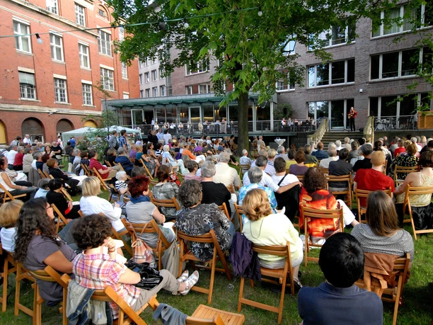 Haus des Buches - Moderne Architektur in Leipzig Der Innenhof des Haus des Buches ist beim Sommerfest des Literaturcafés voller Menschen, Veranstaltungen, Buchstadt, Kultureinrichtung, Architektur in Leipzig