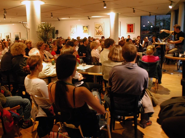 Haus des Buches - Moderne Architektur in Leipzig Der Innenraum des Haus des Buches ist beim Sommerfest des Literaturcafés voller Menschen, Veranstaltungen, Buchstadt, Kultureinrichtung, Architektur in Leipzig