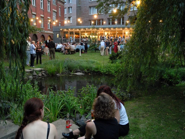 Haus des Buches - Moderne Architektur in Leipzig Der Innenhof des Haus des Buches ist beim Sommerfest des Literaturcafés voller Menschen, Veranstaltungen, Buchstadt, Kultureinrichtung, Architektur in Leipzig