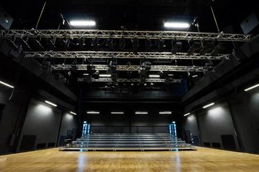 Widok ze sceny w teatrze LOFFT na rzędy widzów w sali o czarnych ścianach z oświetleniem, instytucja kultury, czas wolny
