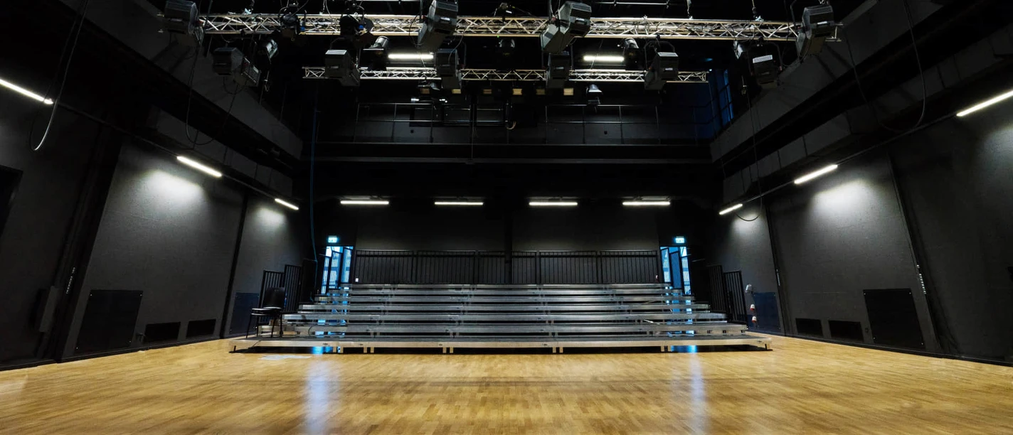 Théâtre LOFFT - Scènes à Leipzig Vue de la scène du théâtre LOFFT sur les rangées de spectateurs dans une salle aux murs noirs avec éclairage, équipement culturel, loisirs