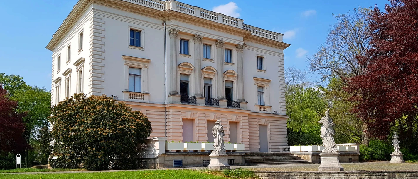 Bílý dům v parku Markkleeberg - Zajímavá místa v regionu Lipsko Pohled zvenčí na Bílý dům v parku Agra v Markkleebergu, který je inspirován versailleským letohrádkem Petit Trianon, s terasou za slunečného počasí, Exkurze, Lipsko
