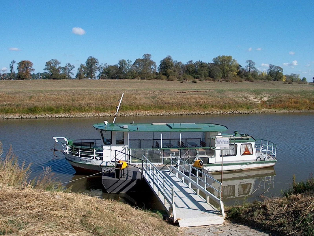 Motorboot Roland Ein grünes Motorboot mit Rampe liegt friedlich am Flussufer vor Anker.
