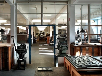 Museum für Druckkunst - Museen in Leipzig Blick in den Raum des Museums für Druckkunst mit vielen Materialien und historischen Druckmaschinen für künstlerische Druckverfahren.