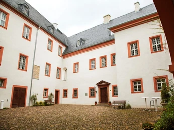 Innenhof Schloss Frohburg - Schlösser in der Leipzig Region Während die Außenfassade des Schloss Frohburg gelb ist, ist die Fassade im Innenhof weiß mit roten Rahmen um jedes Fenster, Ausflug, Leipzig Region