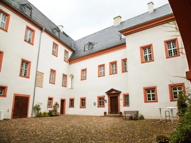 Innenhof Schloss Frohburg - Schlösser in der Leipzig Region Während die Außenfassade des Schloss Frohburg gelb ist, ist die Fassade im Innenhof weiß mit roten Rahmen um jedes Fenster, Ausflug, Leipzig Region