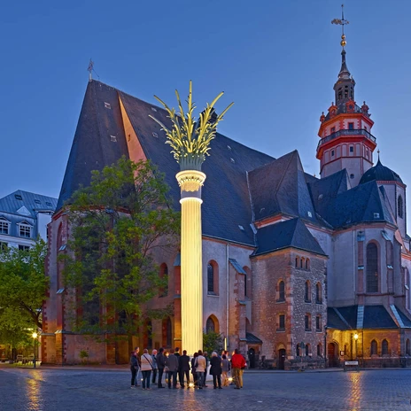 Widok na Nikolaikirche i Nikolaisäule na Nikolaikirchhof wieczorem, gdzie odbyły się modlitwy o pokój, które doprowadziły do pokojowej rewolucji, instytucja kultury, historia Lipska, ciekawe miejsca