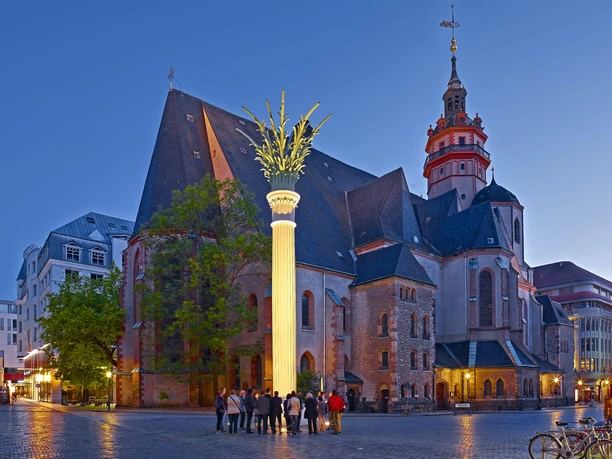 Widok na Nikolaikirche i Nikolaisäule na Nikolaikirchhof wieczorem, gdzie odbyły się modlitwy o pokój, które doprowadziły do pokojowej rewolucji, instytucja kultury, historia Lipska, ciekawe miejsca