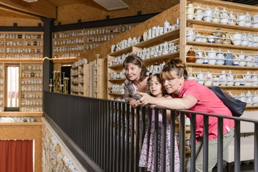 Une famille se tient dans le "O", le hall multifonctionnel du parc O-Schatz, et admire l'immense collection de cafetières.