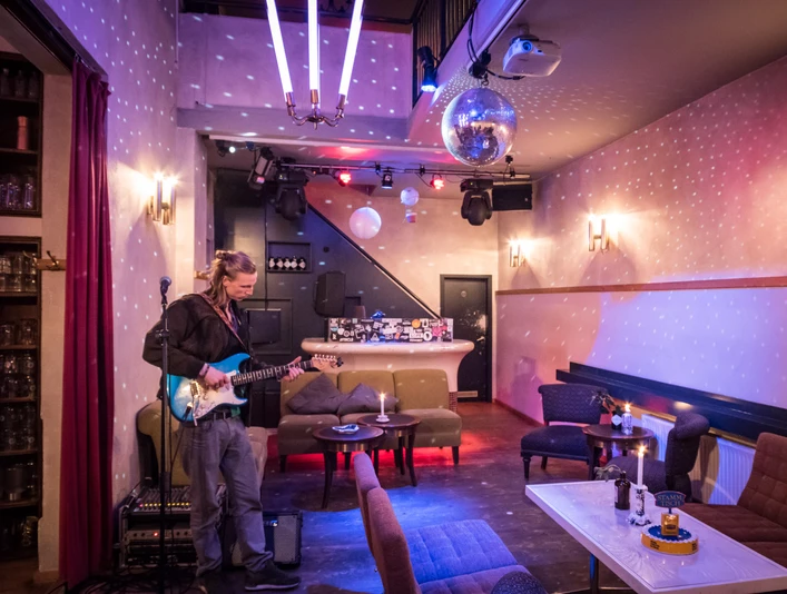 Oskar - Gastronomie in Leipzig Zusehen ist die kleine Bühne im Oskar mit einem Musiker mit E-Gitarre, Gastronomie, Bar, Restaurant, Freisitz