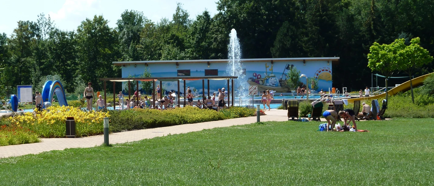 Parthebad w Taucha z trawnikiem do opalania, basenem wodnym, terenem sportowym i placem zabaw.