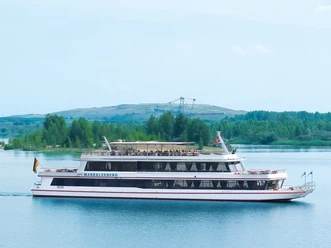MS Markkleeberg sur le lac de Markkleeberg - Navigation de passagers dans le Neuseenland de Leipzig Le MS Markkleeberg de la compagnie de navigation de passagers du Leipziger Neuseenland navigue sur le lac de Markkleeberg avec des invités à bord, on peut voir le parc technique minier en arrière-plan, excursion, activité de loisirs