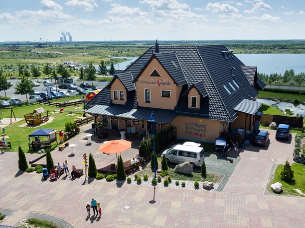 Vue sur le restaurant Seeperle dans le Seepark Auenhain avec le lac de Markkleeberg, le Kanupark et le Bergbau-Technik-Park en arrière-plan par temps ensoleillé, gastronomie d'excursion, Leipziger Neuseenland