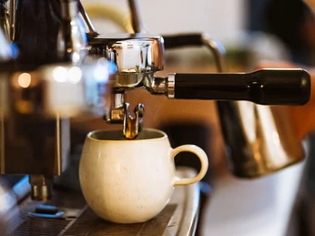 Roots Pflanzencafé - Cafés in Leipzig Eine Kaffeetasse steht unter einer Siebträgermaschine im Roots Pflanzencafé, gastronomie, kaffee