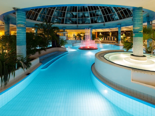 Illuminated swimming pool in the Sachsen-Therme Leipzig in the evening.