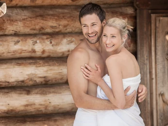 Erdsauna in der Sachsen-Therme - Freizeiteinrichtung in Leipzig Ein glückliches Paar Arm in Arm mit Handtüchern bekleidet vor der Erdsauna in der Sachsen-Therme Leipzig.