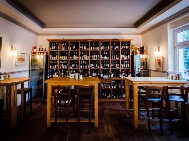 View into the delicatessen with bistro; seating area, wooden shelves with a variety of wines and wonderful lighting, restaurant, gastronomy