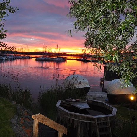 Außenanlage der Sauna im See am Cospudener See bei Sonnenuntergang