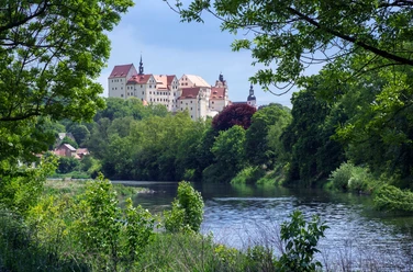 Widok z drugiego brzegu rzeki na zamek Colditz, który góruje nad Muldą w regionie Lipska