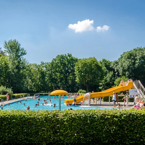 Vue sur la piscine principale du Schreberbad, avec toboggan jaune et de nombreux baigneurs un jour d'été, activité de loisirs, plaisir de la baignade