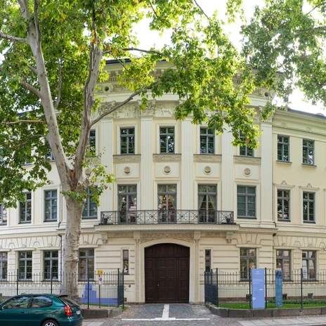 Widok na klasycystyczną fasadę Domu Schumanna w Lipsku, w otoczeniu drzew, kultury, muzyki, kompozytorów