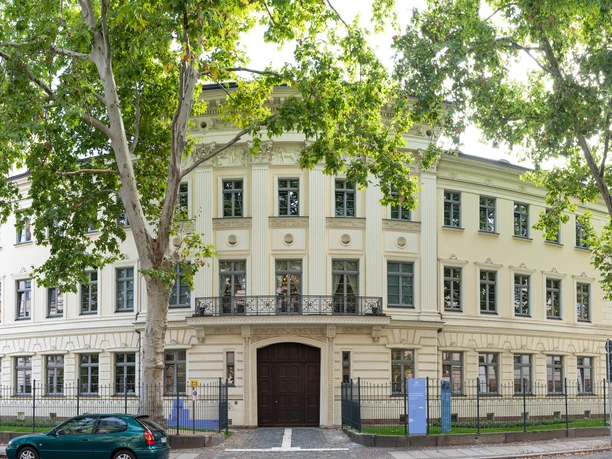 Widok na klasycystyczną fasadę Domu Schumanna w Lipsku, w otoczeniu drzew, kultury, muzyki, kompozytorów