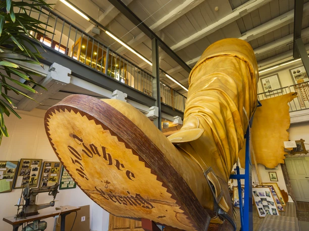 DEU/Saxe/ Leisnig Avec une hauteur de tige de 4,90 m et une longueur de semelle de 2,20 m, la botte géante de Leisnig détient le record Guinness de la plus grande botte du monde. Sa fabrication a nécessité 140 kg de cuir de semelle provenant de 10 peaux de bœuf et la roue à éperons, dotée de 16 pointes, a à elle seule un diamètre de 55 cm. Le 21 juin 1996, à l'occasion du 950e anniversaire de la ville de Leisnig, les maîtres cordonniers Gerhard Berthold et Rolf Neidhardt ont présenté, à la surprise des habitants de Leisnig et à l'horreur de la population de Döbeln, la botte géante de Leisnig, encore plus grande, avec les dimensions mentionnées ci-dessus. Ils l'avaient fabriquée dans le plus grand secret dans leur atelier, où ils avaient spécialement percé le plafond de l'étage supérieur. En raison de sa taille, elle a été inscrite en 1997 dans le livre Guinness des records en tant que plus grande botte à manchettes du monde. Le musée de la botte de Leisnigen a été inauguré en 2006 à l'occasion de la fête du château et de la vieille ville. La maison "am Burglehn", située dans la zone de l'ancien avant-château du château de Mildenstein, offre avec ses 1000 ans d'histoire un logement optimal à la botte géante de Leisnig. En outre, elle abrite la galerie Wagler, ancienne demeure du peintre Karl Wagler. DEU/Saxe/ Leisnig Avec une hauteur de tige de 4,90 m et une longueur de semelle de 2,20 m, la botte géante de Leisnig détient le record Guinness de la plus grande botte du monde. Sa fabrication a nécessité 140 kg de cuir de semelle provenant de 10 peaux de bœuf et la roue à éperons, dotée de 16 pointes, a à elle seule un diamètre de 55 cm. Le 21 juin 1996, à l'occasion du 950e anniversaire de la ville de Leisnig, les maîtres cordonniers Gerhard Berthold et Rolf Neidhardt ont présenté, à la surprise des habitants de Leisnig et à l'horreur de la population de Döbeln, la botte géante de Leisnig, encore plus grande, avec les dimensions mentionnées ci-dessus. Ils l'avaient fabriquée dans le plus grand secret dans leur atelier, où ils avaient spécialement percé le plafond de l'étage supérieur. En raison de sa taille, elle a été inscrite en 1997 dans le livre Guinness des records en tant que plus grande botte à manchettes du monde. Le musée de la botte de Leisnigen a été inauguré en 2006 à l'occasion de la fête du château et de la vieille ville. La maison "am Burglehn", située dans la zone de l'ancien avant-château du château de Mildenstein, offre avec ses 1000 ans d'histoire un logement optimal à la botte géante de Leisnig. En outre, elle abrite la galerie Wagler, ancienne demeure du peintre Karl Wagler.